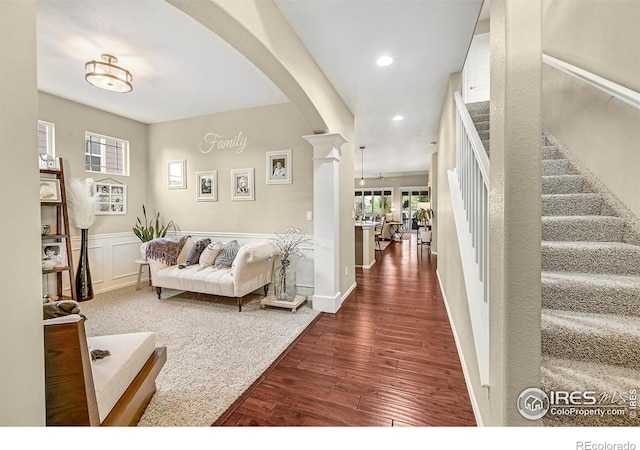 entryway with decorative columns, a wainscoted wall, wood finished floors, stairs, and recessed lighting