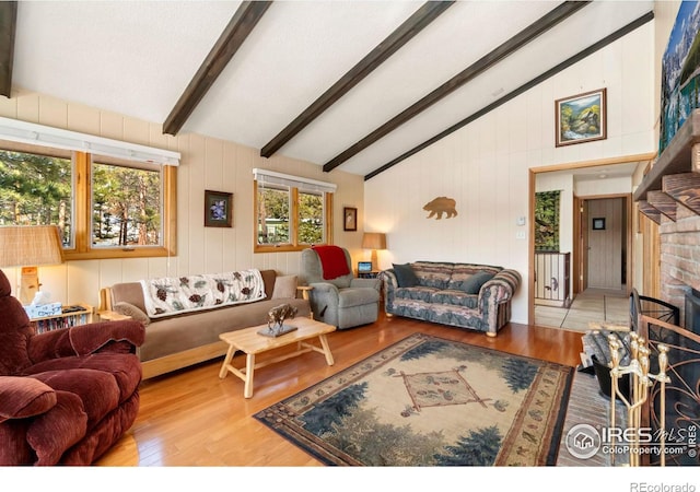 living area with a brick fireplace, beam ceiling, high vaulted ceiling, and wood finished floors