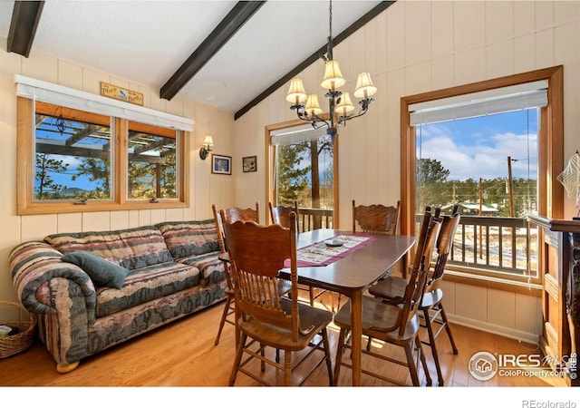 dining room with a notable chandelier, lofted ceiling with beams, and wood finished floors