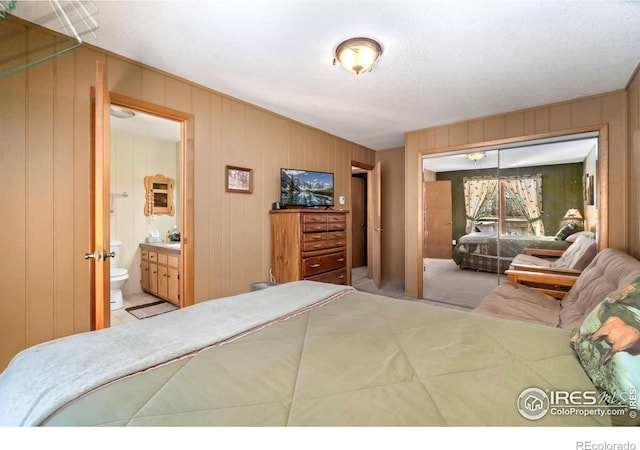 bedroom with carpet, a closet, and ensuite bathroom