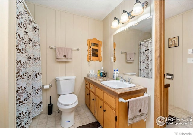 bathroom featuring tile patterned flooring, a shower with curtain, vanity, and toilet