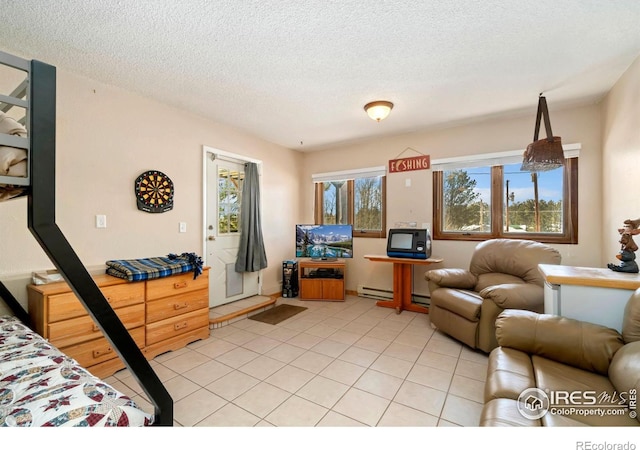 living area featuring light tile patterned floors, baseboard heating, and a textured ceiling