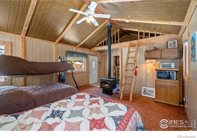 bedroom featuring wooden walls, lofted ceiling with beams, wood ceiling, a wood stove, and carpet