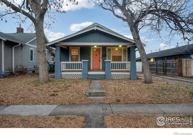 bungalow-style house with covered porch and fence