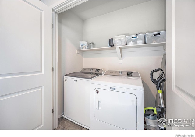 clothes washing area featuring laundry area, tile patterned floors, and washer and dryer