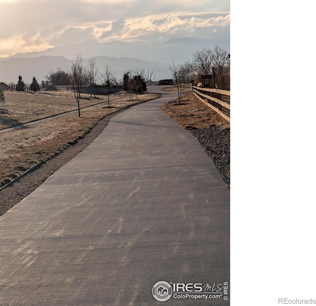 view of road with a rural view and a mountain view