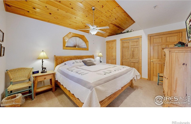 bedroom featuring a ceiling fan, wood ceiling, vaulted ceiling, carpet floors, and two closets