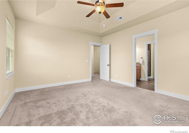 5850 Dripping Rock Ln Unit D201, Fort Collins, CO 80528 - unfurnished bedroom featuring baseboards, visible vents, ensuite bathroom, a tray ceiling, and carpet flooring