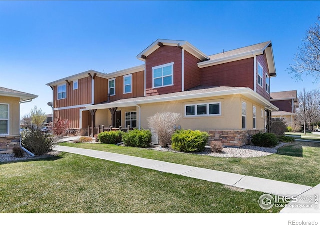 5850 Dripping Rock Ln Unit D201, Fort Collins, CO 80528 - view of front of property featuring a front yard, stone siding, and stucco siding