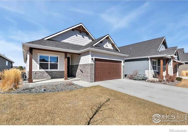 view of front of home with a garage, stone siding, roof with shingles, and driveway