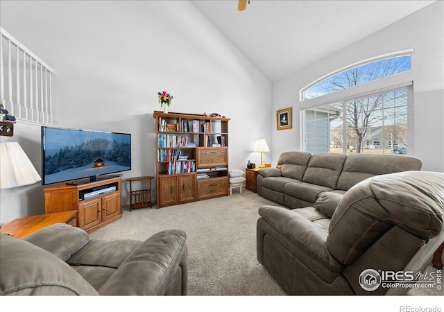 living area with carpet and high vaulted ceiling