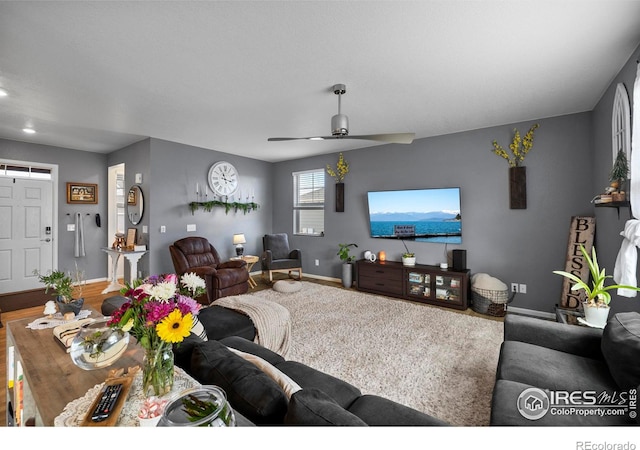 living room with ceiling fan and baseboards