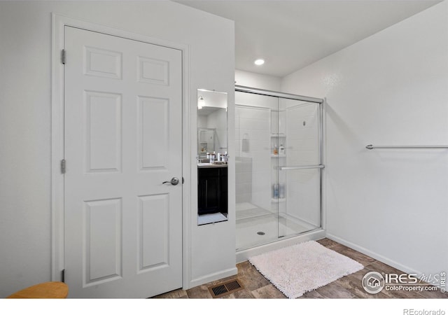 bathroom featuring vanity, a shower stall, visible vents, and baseboards