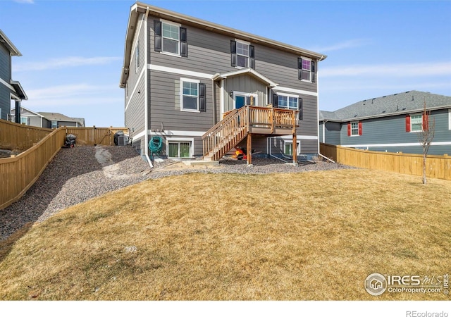 back of house with a fenced backyard, stairway, a deck, and a yard