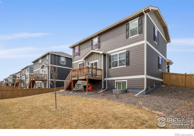 back of property with stairway, fence, a deck, and board and batten siding