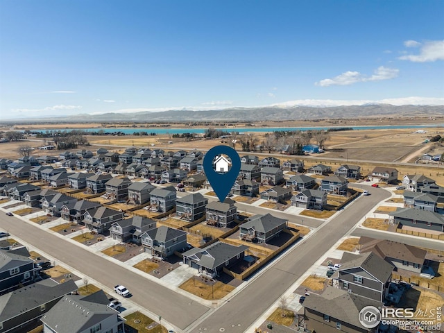 drone / aerial view featuring a water and mountain view and a residential view