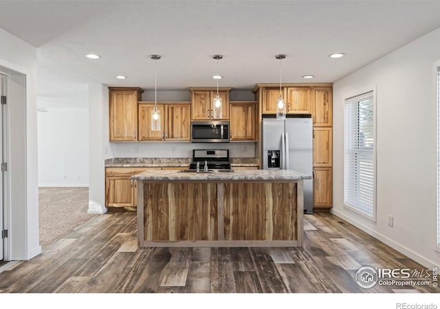 kitchen with a center island with sink, appliances with stainless steel finishes, dark wood-style flooring, pendant lighting, and recessed lighting