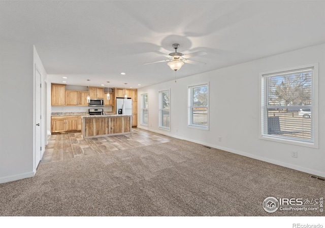 unfurnished living room with recessed lighting, light carpet, and baseboards