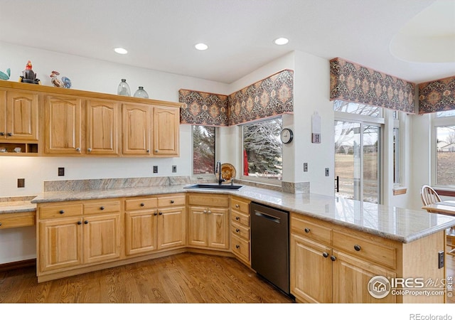 kitchen featuring light countertops, light wood-style flooring, a sink, dishwasher, and a peninsula