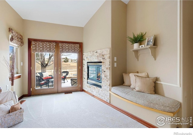 interior space featuring carpet flooring, visible vents, baseboards, french doors, and a glass covered fireplace