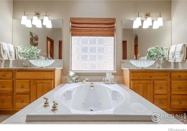 full bath with two vanities, a sink, and a whirlpool tub