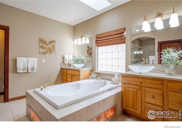 bathroom with a skylight, tiled shower, two vanities, a sink, and a bath