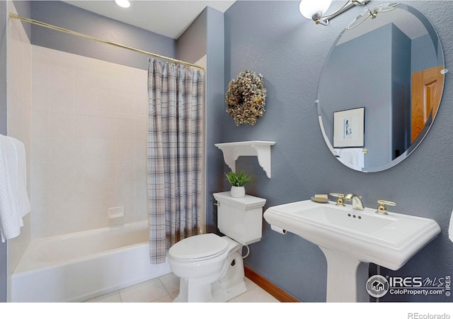 bathroom featuring a sink, tile patterned flooring, toilet, and shower / bathtub combination with curtain