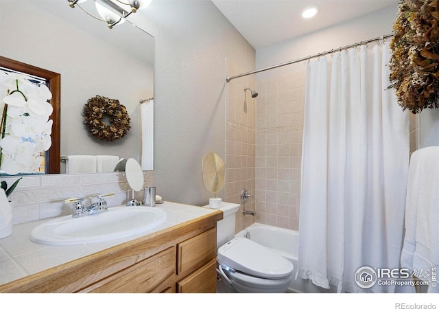 bathroom featuring toilet, shower / bath combination with curtain, and vanity