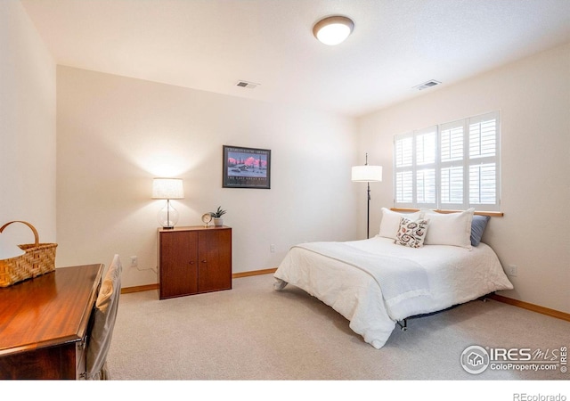 carpeted bedroom featuring baseboards and visible vents