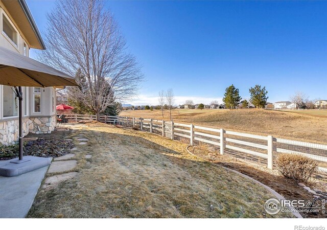 view of yard with a rural view and fence