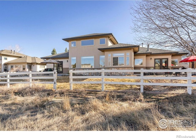 view of front of property featuring fence and stucco siding