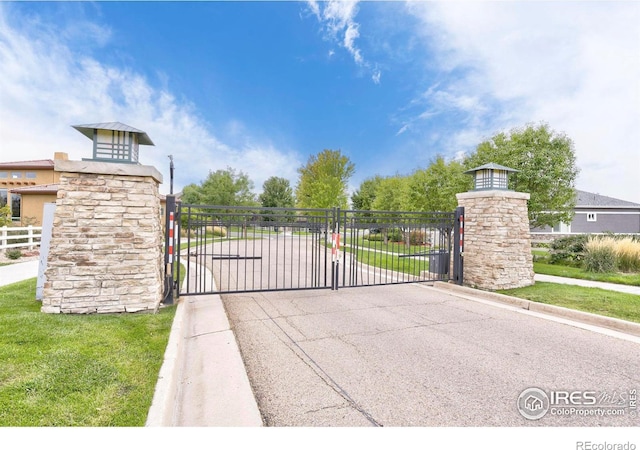 view of gate featuring fence and a lawn