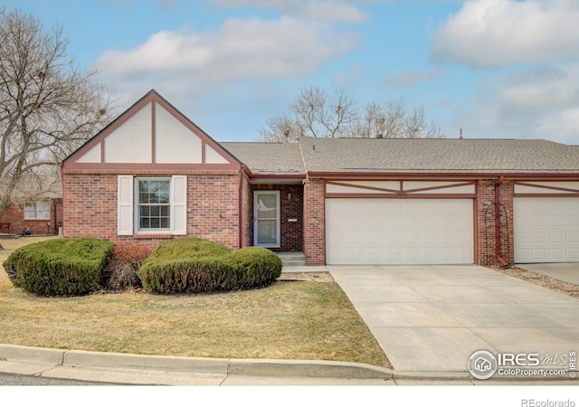 view of front facade with brick siding, a shingled roof, concrete driveway, a front yard, and a garage