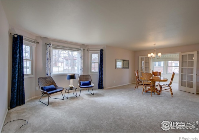 living area with a wealth of natural light, carpet flooring, baseboards, and an inviting chandelier