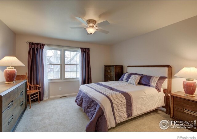 bedroom featuring light colored carpet, visible vents, ceiling fan, and baseboards