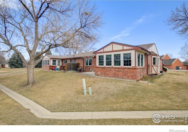 view of front of home with a front yard and brick siding