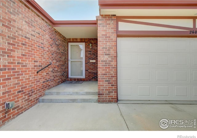 property entrance with concrete driveway and a garage