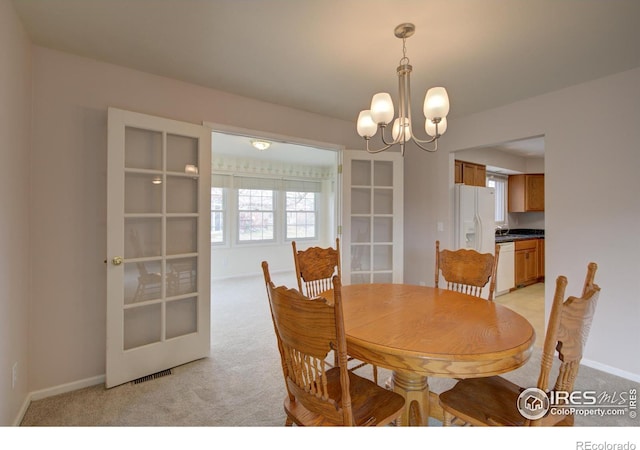 dining room featuring baseboards, light carpet, and an inviting chandelier
