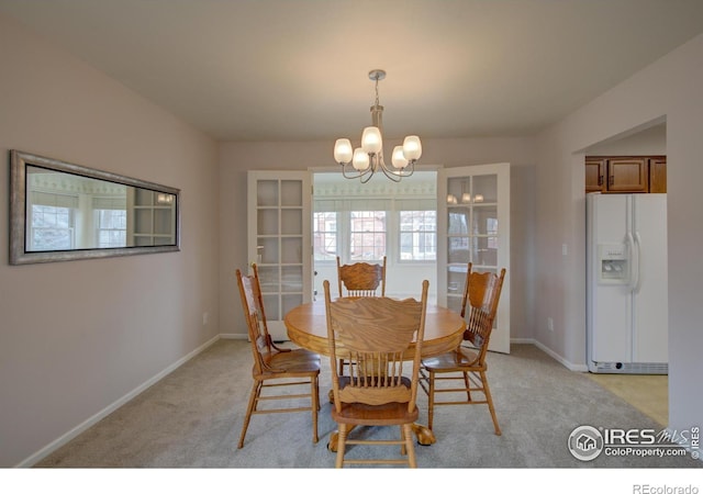 dining space with light colored carpet, baseboards, and a chandelier