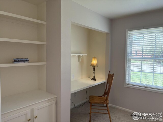 carpeted home office featuring baseboards and built in study area