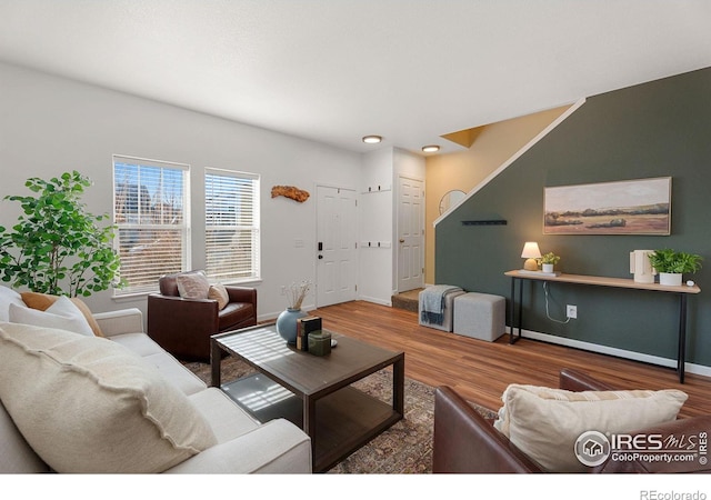 living area with baseboards and wood finished floors