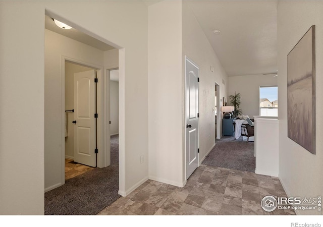 corridor with carpet and baseboards