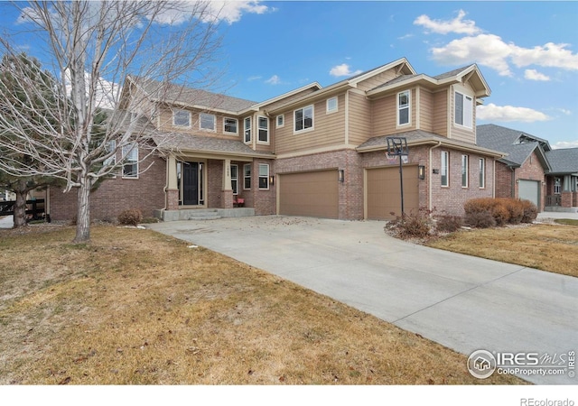 view of front of property with concrete driveway, brick siding, an attached garage, and a front yard