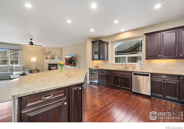 kitchen with wine cooler, backsplash, stainless steel dishwasher, dark wood-type flooring, and a sink