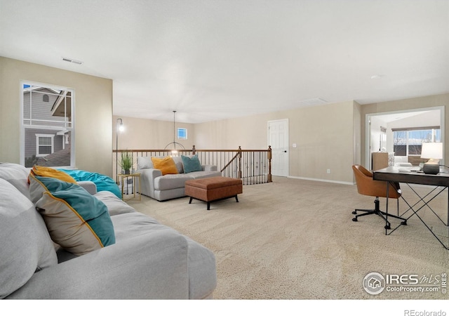 carpeted living area with baseboards and visible vents