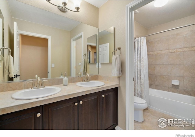 bathroom with double vanity, tile patterned flooring, a sink, and toilet