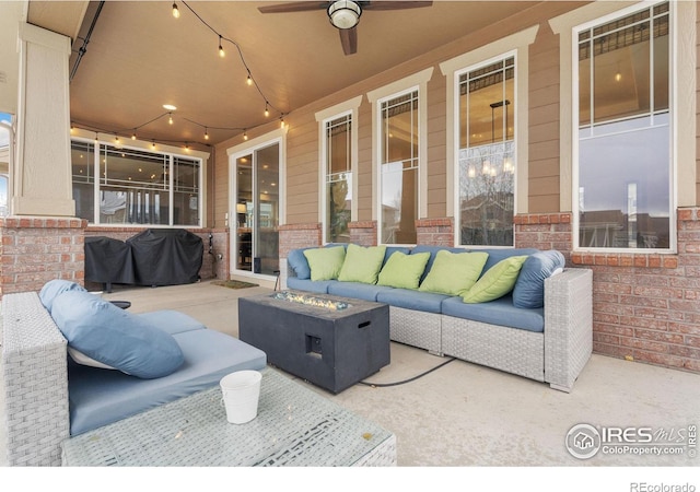 view of patio / terrace with ceiling fan and an outdoor living space with a fire pit