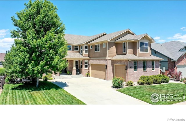 view of front of property featuring a front yard, brick siding, concrete driveway, and a garage