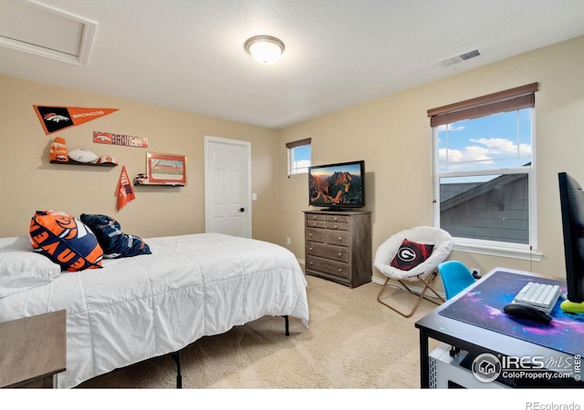 bedroom featuring visible vents, carpet, and attic access