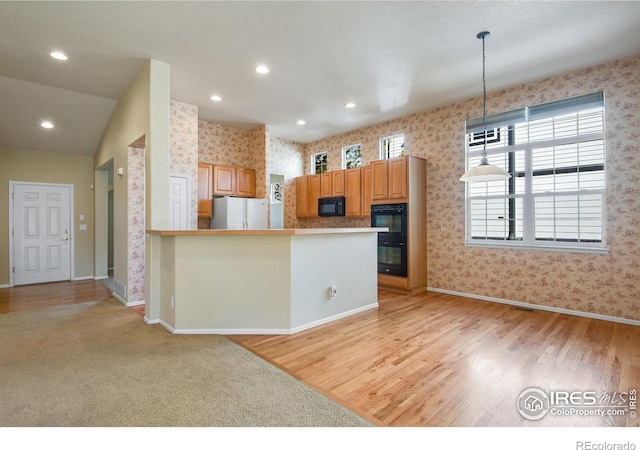 kitchen with black appliances, wallpapered walls, light wood finished floors, and recessed lighting